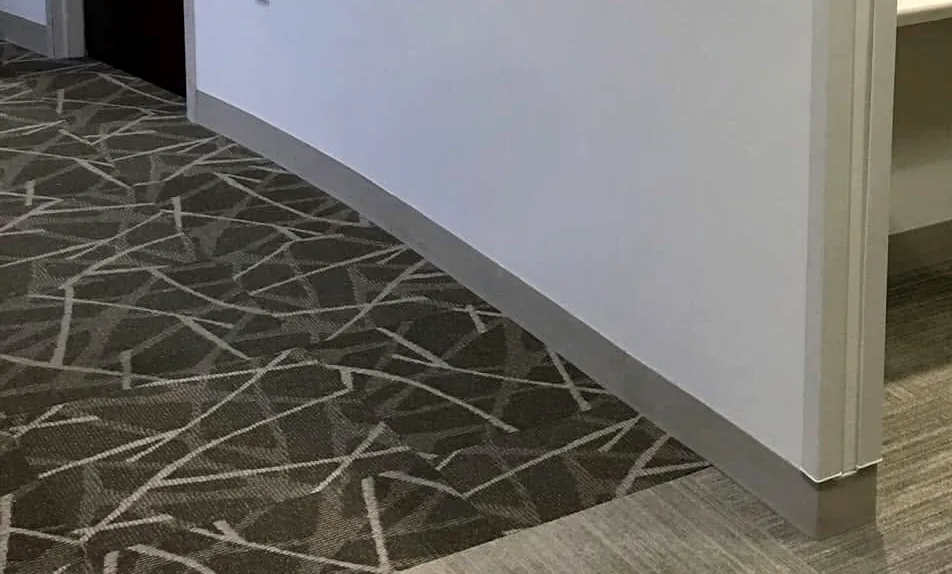 Patton’s work in an office reception: the curved base of the new half wall over the carpet tile.