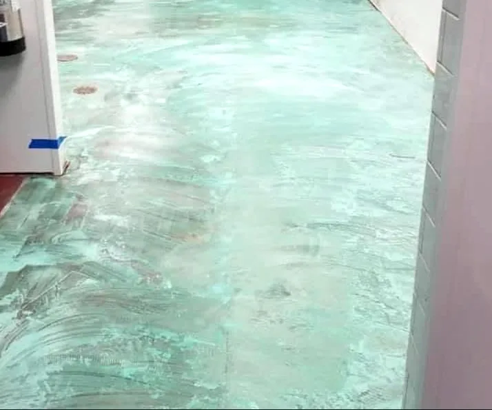 The floor covered in a fresh teal base coat.